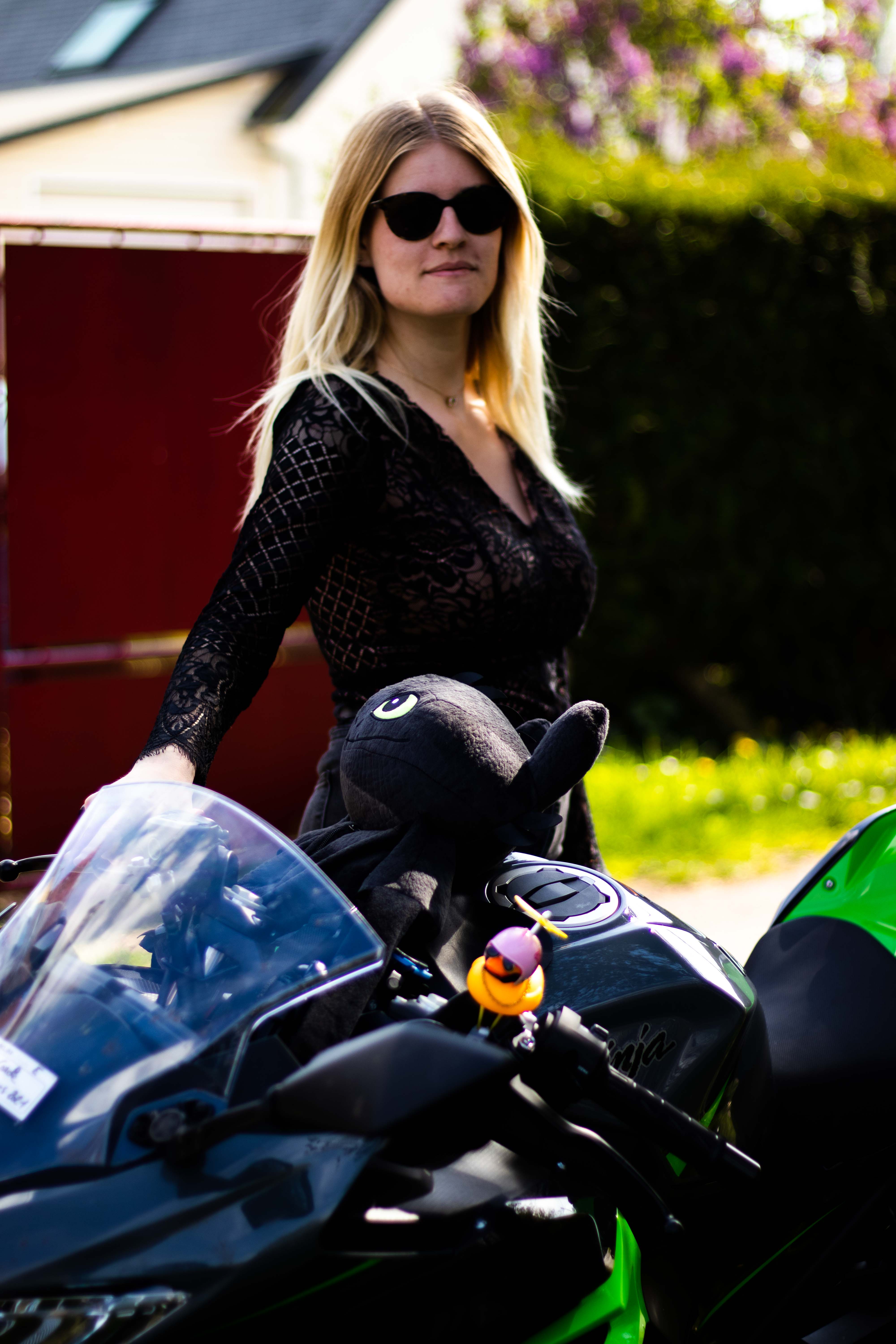 Photo d'une femmme avec des lunettes de soleil tenant le guidon d'une moto avec la main droite